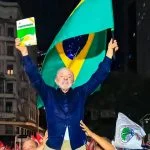Lula chama atenção ao levantar livro da Constituição e erguer bandeira do Brasil durante ato de campanha